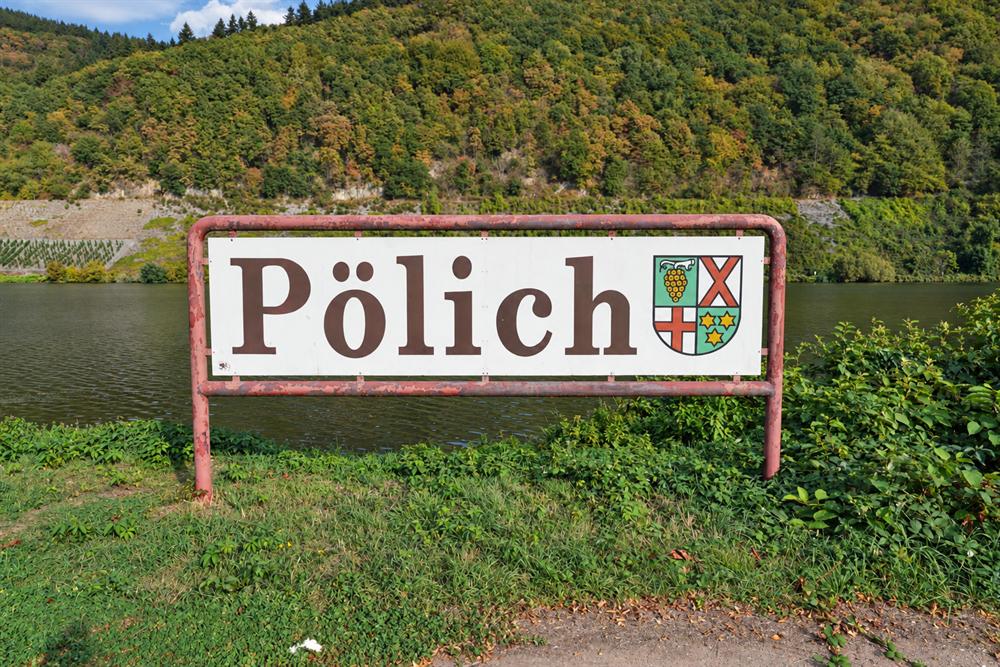Plaatsnaambord Pölich voor de Moezel en de beboste hellingen